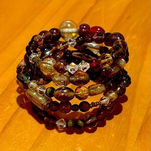 Multicolor (red/gold overall look) wide wire wrap glass bead bracelet.